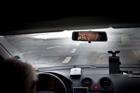 a man driving holding his hands over his eyes
