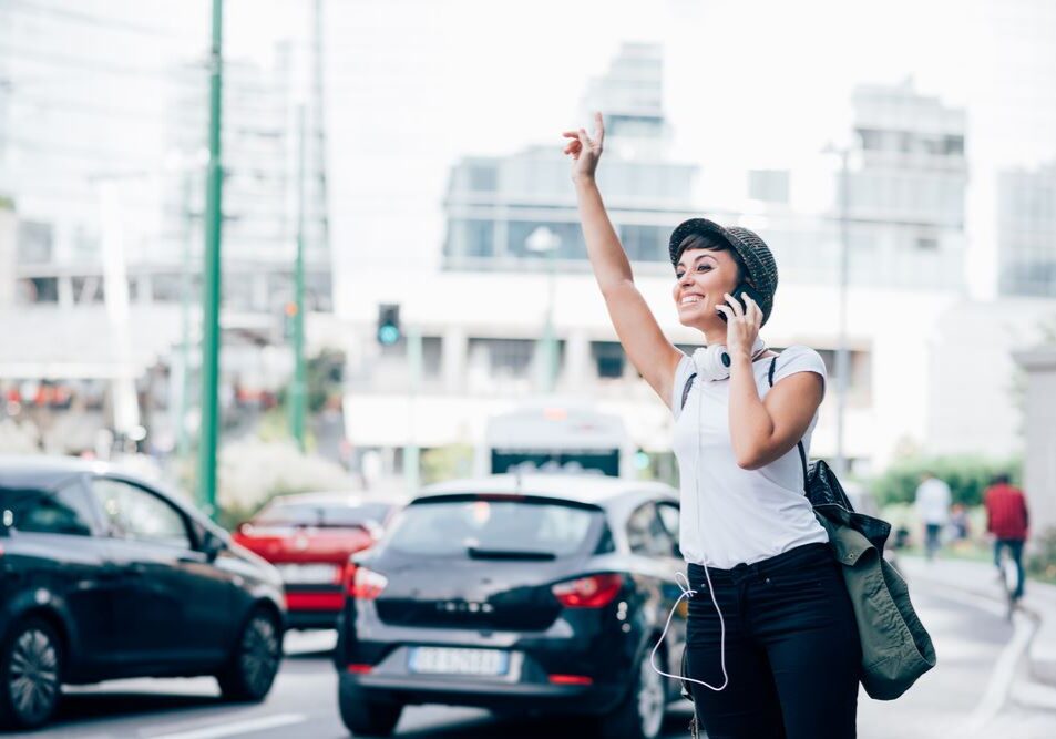 girl-looking-for-a-car-uber-ride-taxi-phone-smile